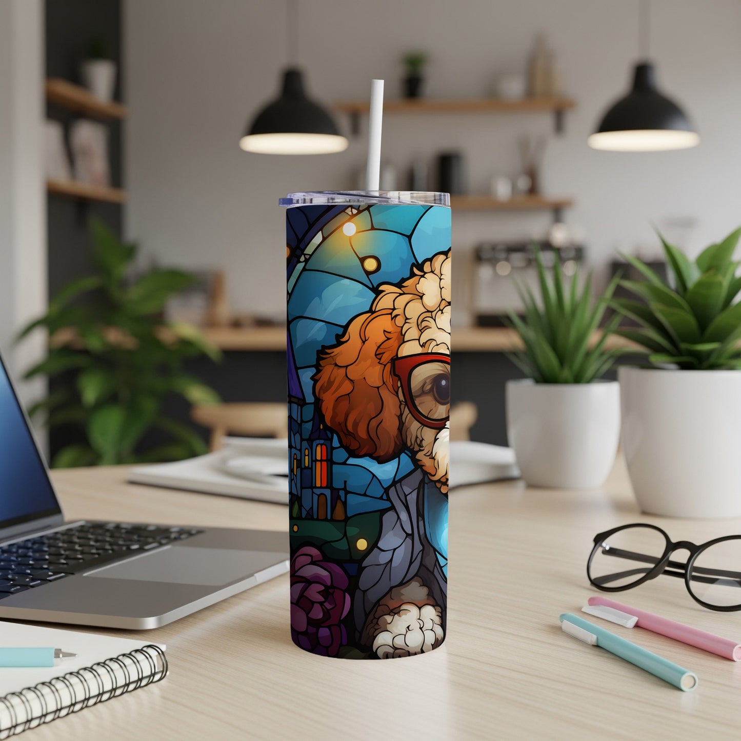 Tumbler with stained-glass dog design and straw on a wooden desk.