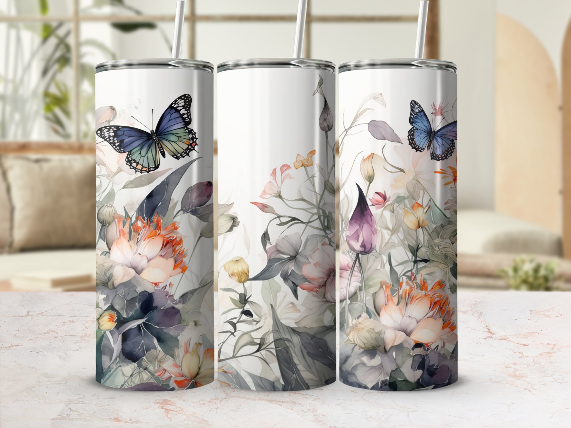 Floral and butterfly pattern on three white tumblers with straws.