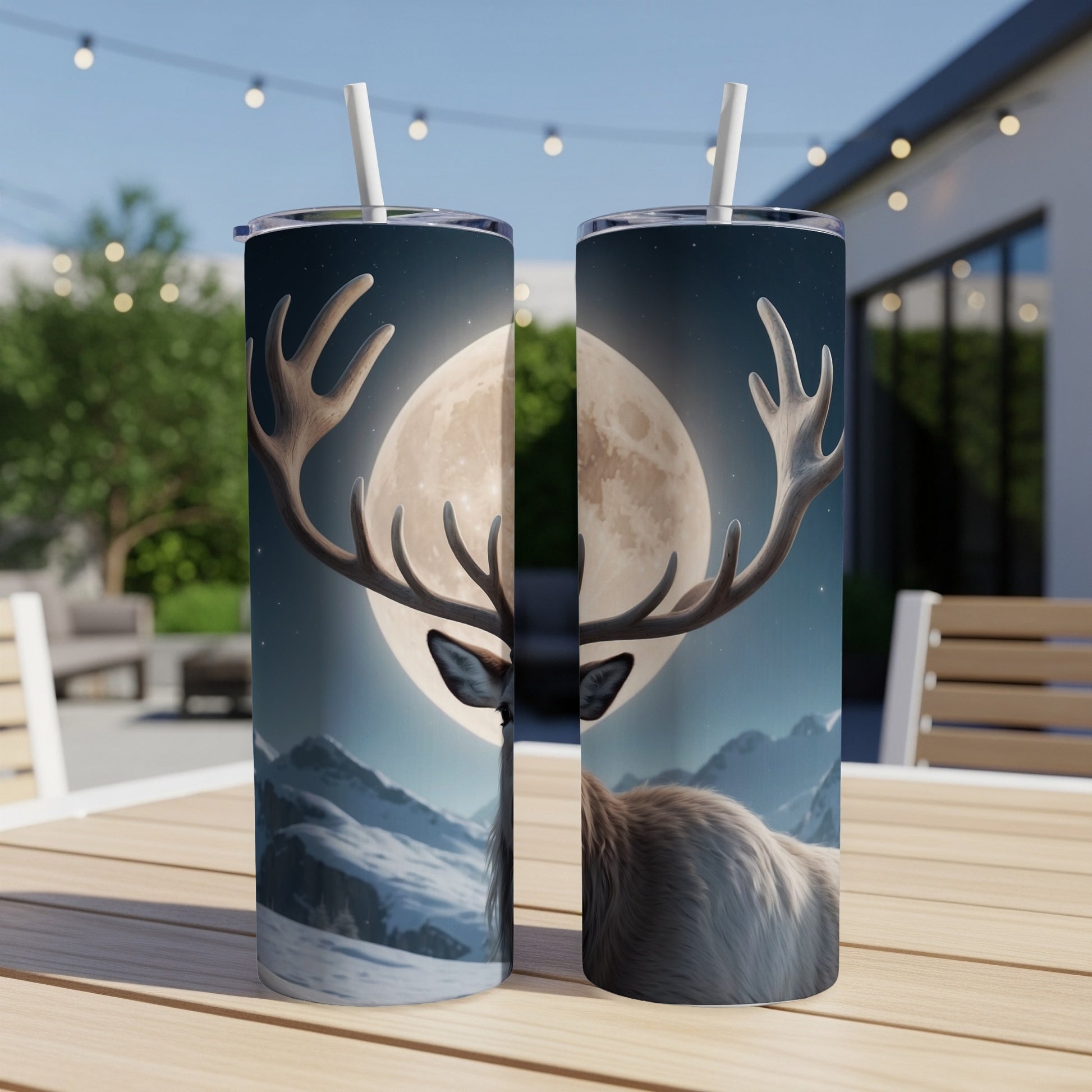 Two tumblers with a deer and moon design, displayed outdoors.