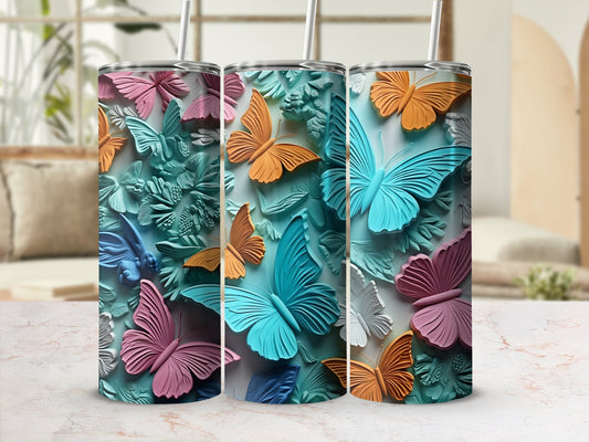 Three tumblers with butterfly and floral patterns in pastel colors.