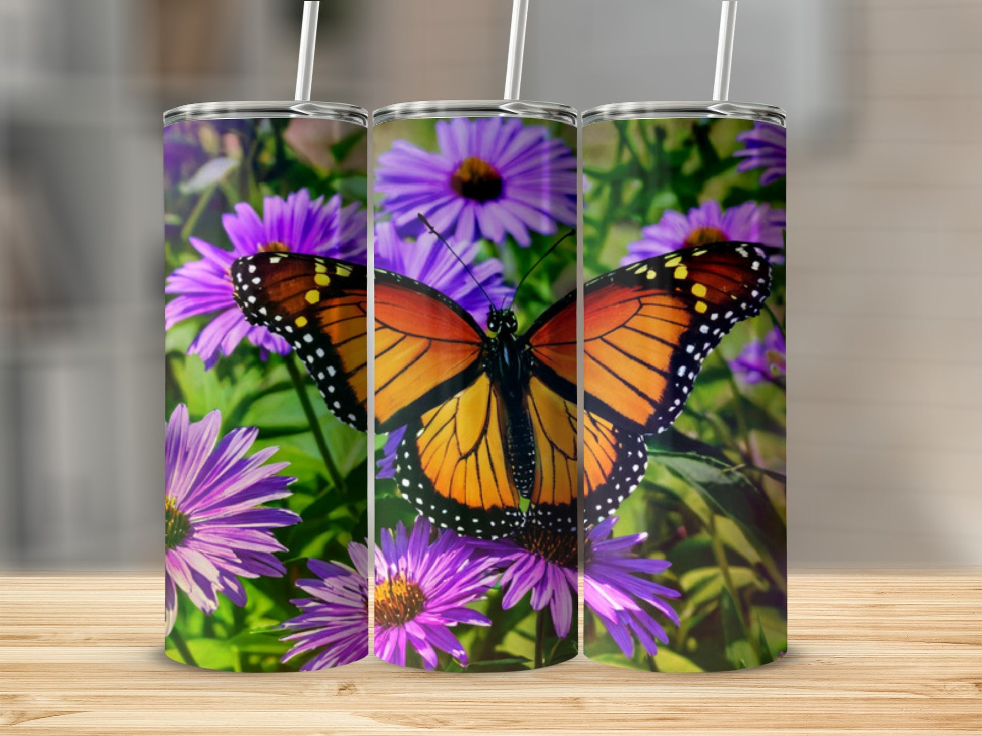Monarch butterfly on purple flowers design on three tumblers.