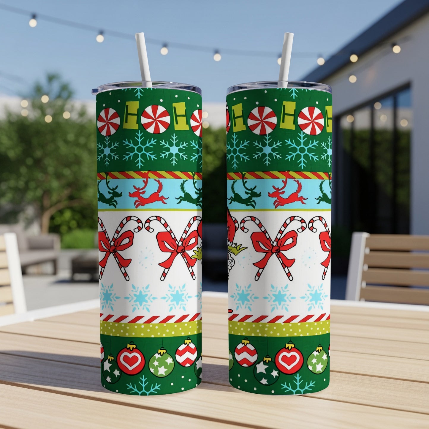 Two tall, skinny tumblers with a festive Christmas pattern of candy canes and snowflakes.