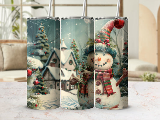 Snowman with scarf and hat in snowy village scene on tumbler.