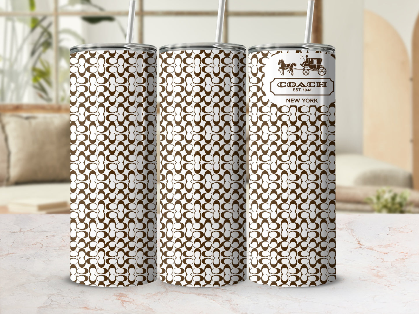 Three Coach pattern tumblers with straws, one displaying the logo and text.