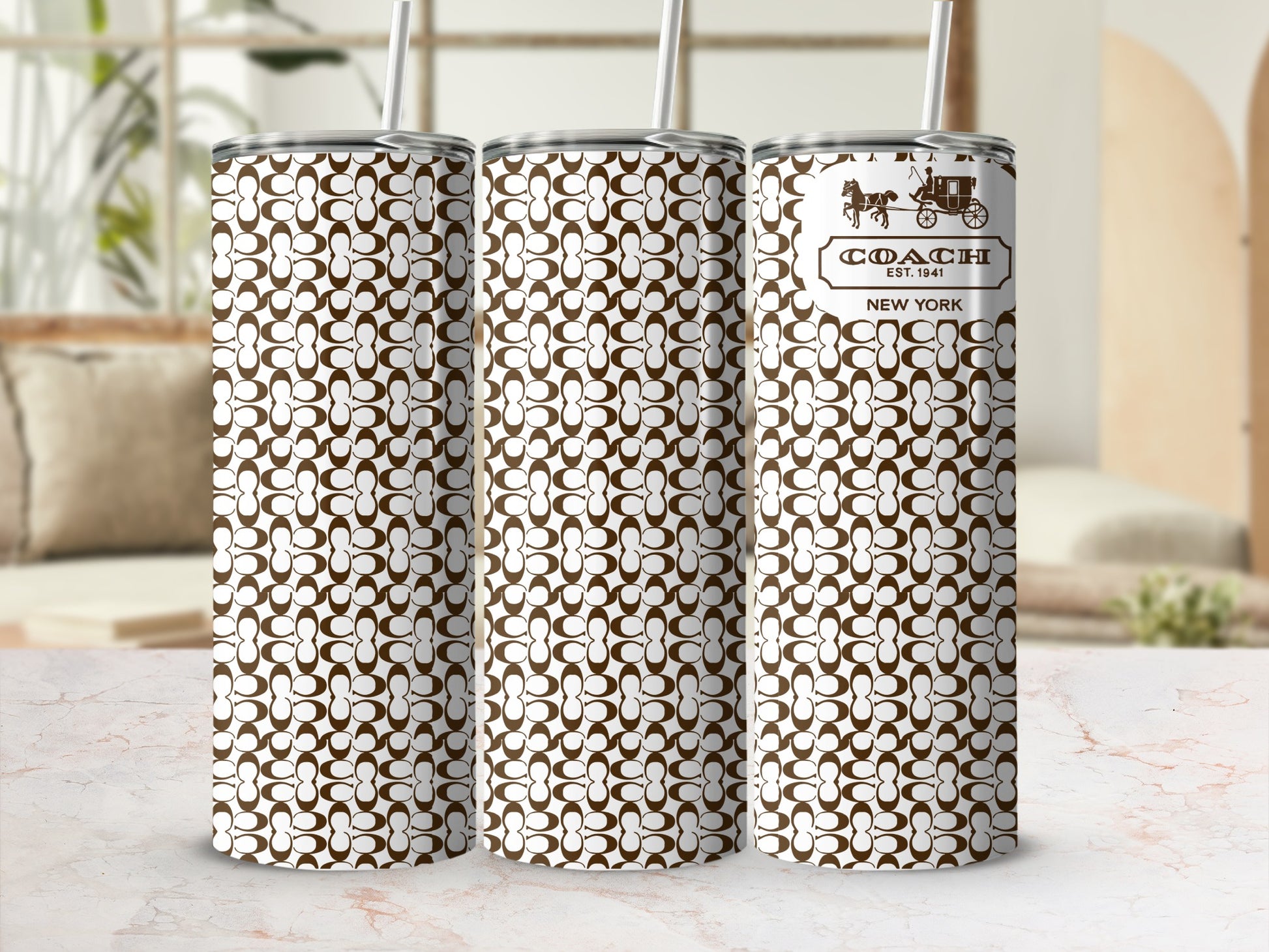 Three Coach pattern tumblers with straws, one displaying the logo and text.