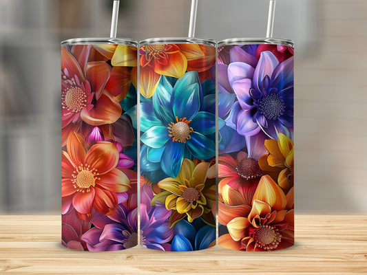 Three colorful floral tumblers with straws on a wooden surface.