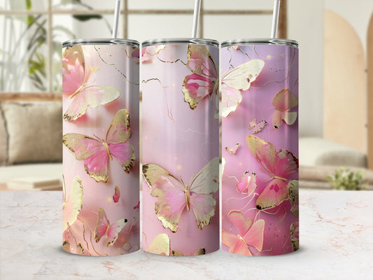 Three tumblers with pink butterflies and gold accents on a white marble surface.