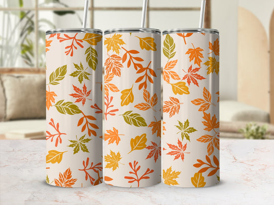 Three tall tumblers with a repeating pattern of autumn leaves in warm fall colors.