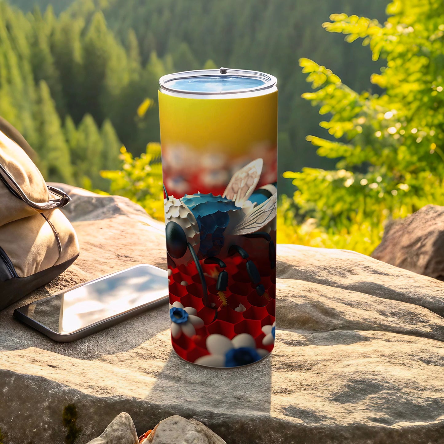 Tumbler with bee design on red and white floral pattern, outdoors.