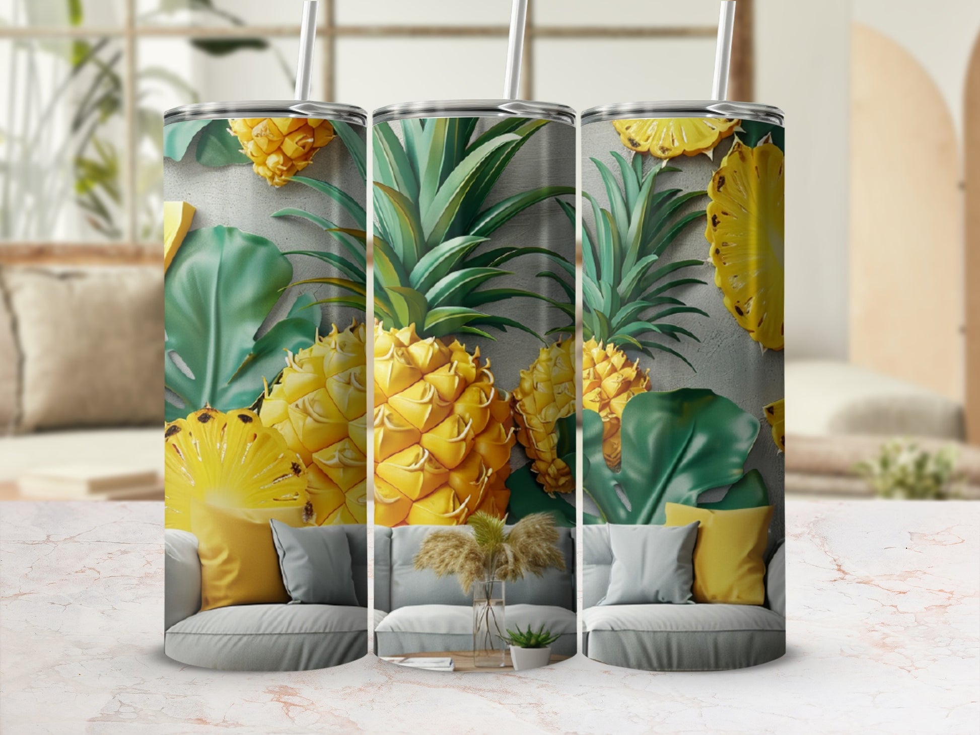 Three tumblers with a pineapple and leaf pattern, on a marbled surface.