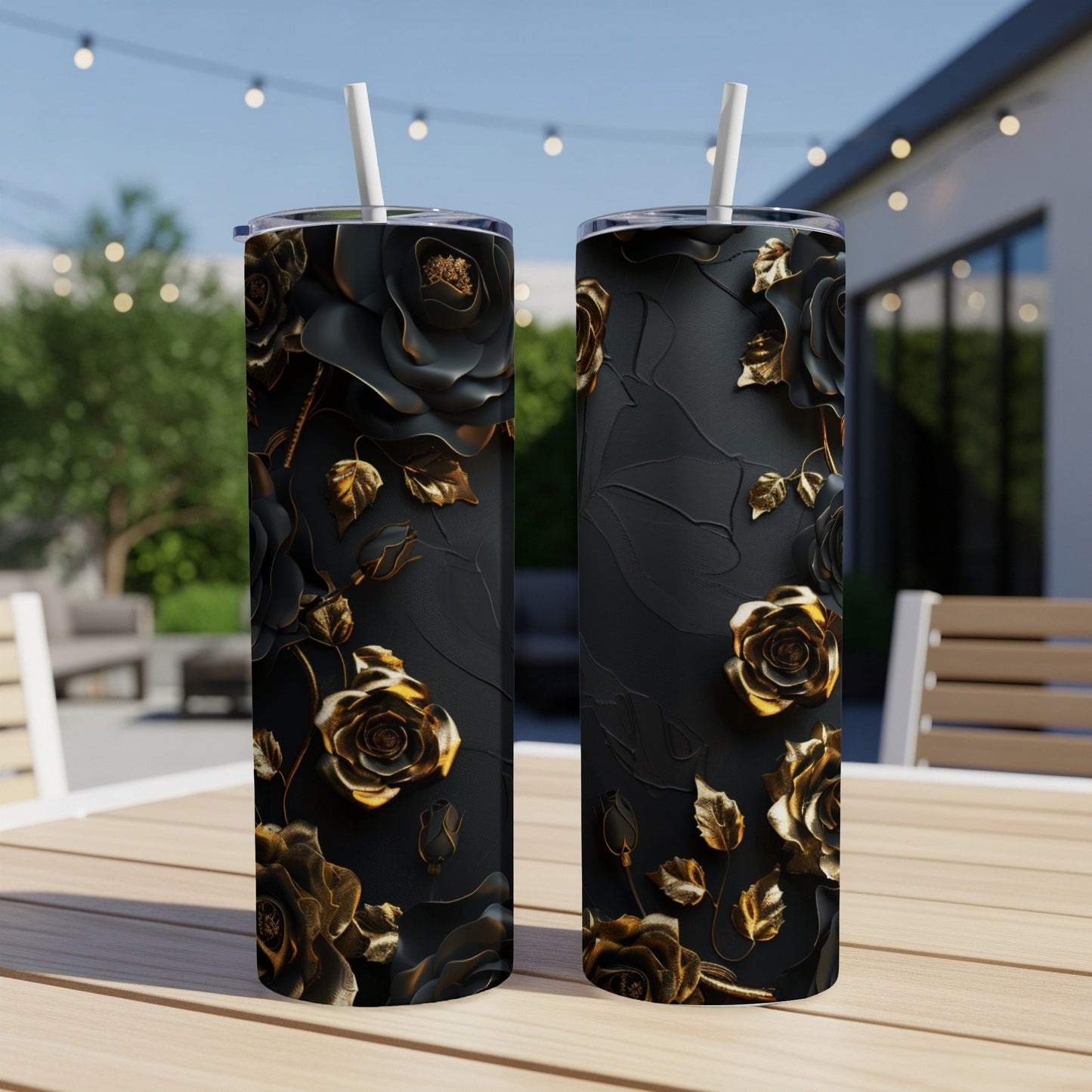 Two black tumblers with embossed gold roses and leaves, standing on a table.
