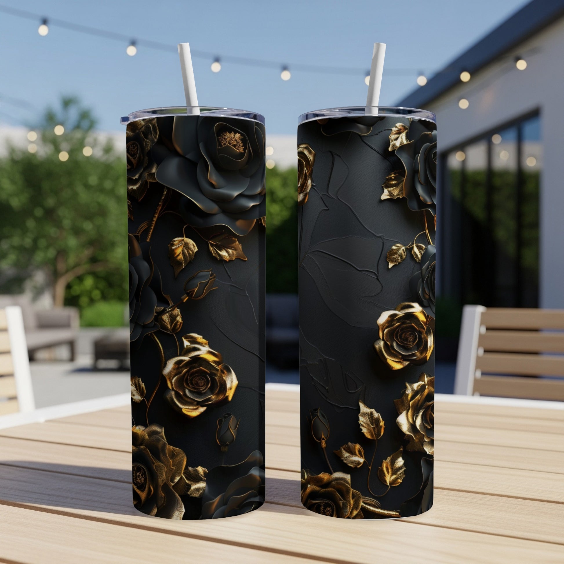 Two black tumblers with embossed gold roses and leaves, standing on a table.