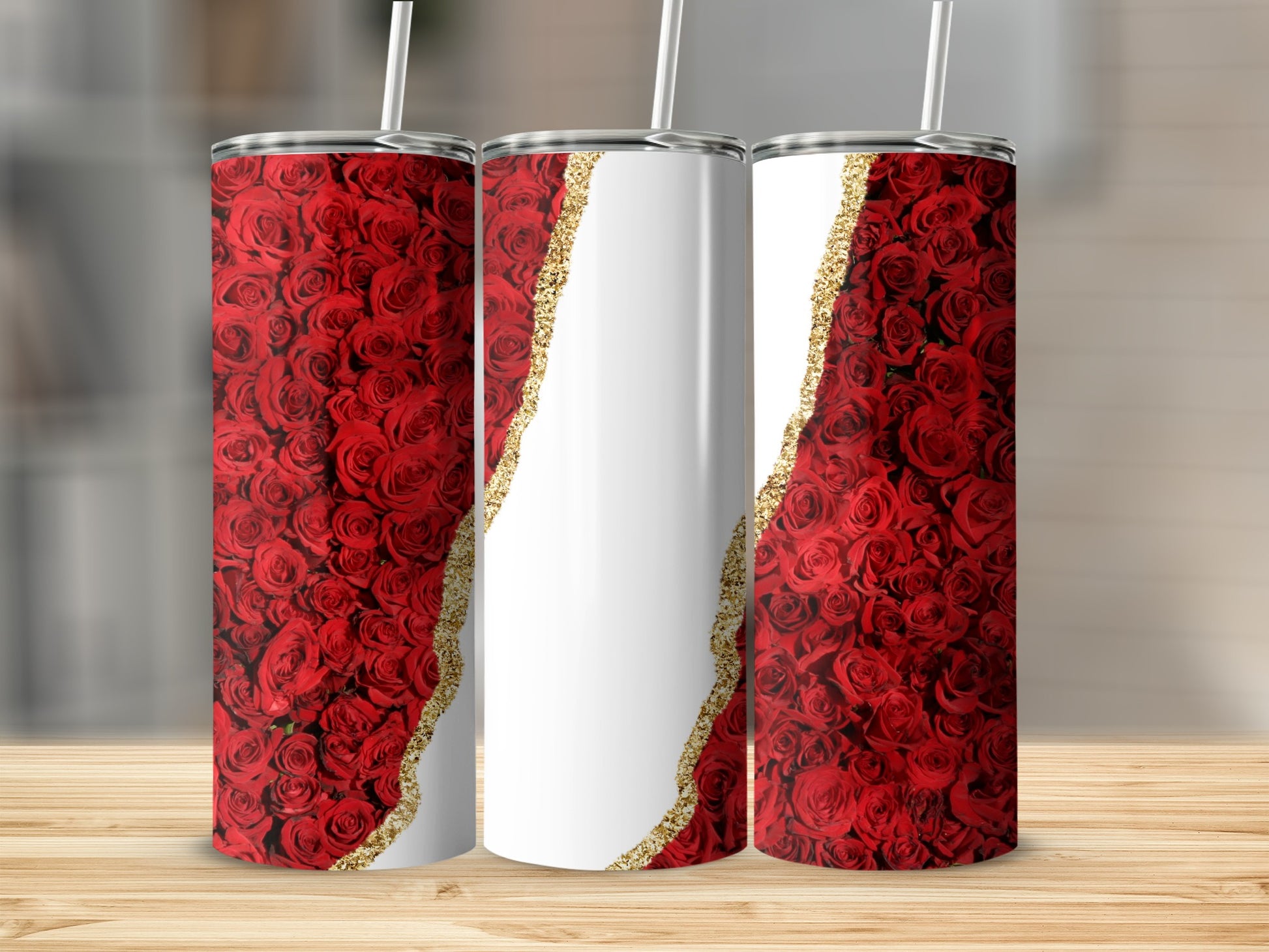 Three tumblers with red roses and gold glitter details on a wooden surface.