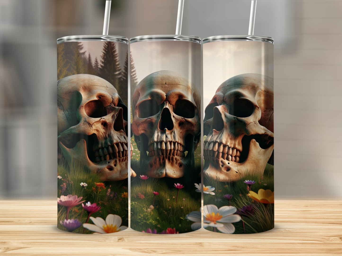 Three tumblers with skull designs in a field of flowers.