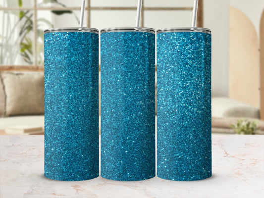 Three blue glitter tumblers with straws on a marble surface.