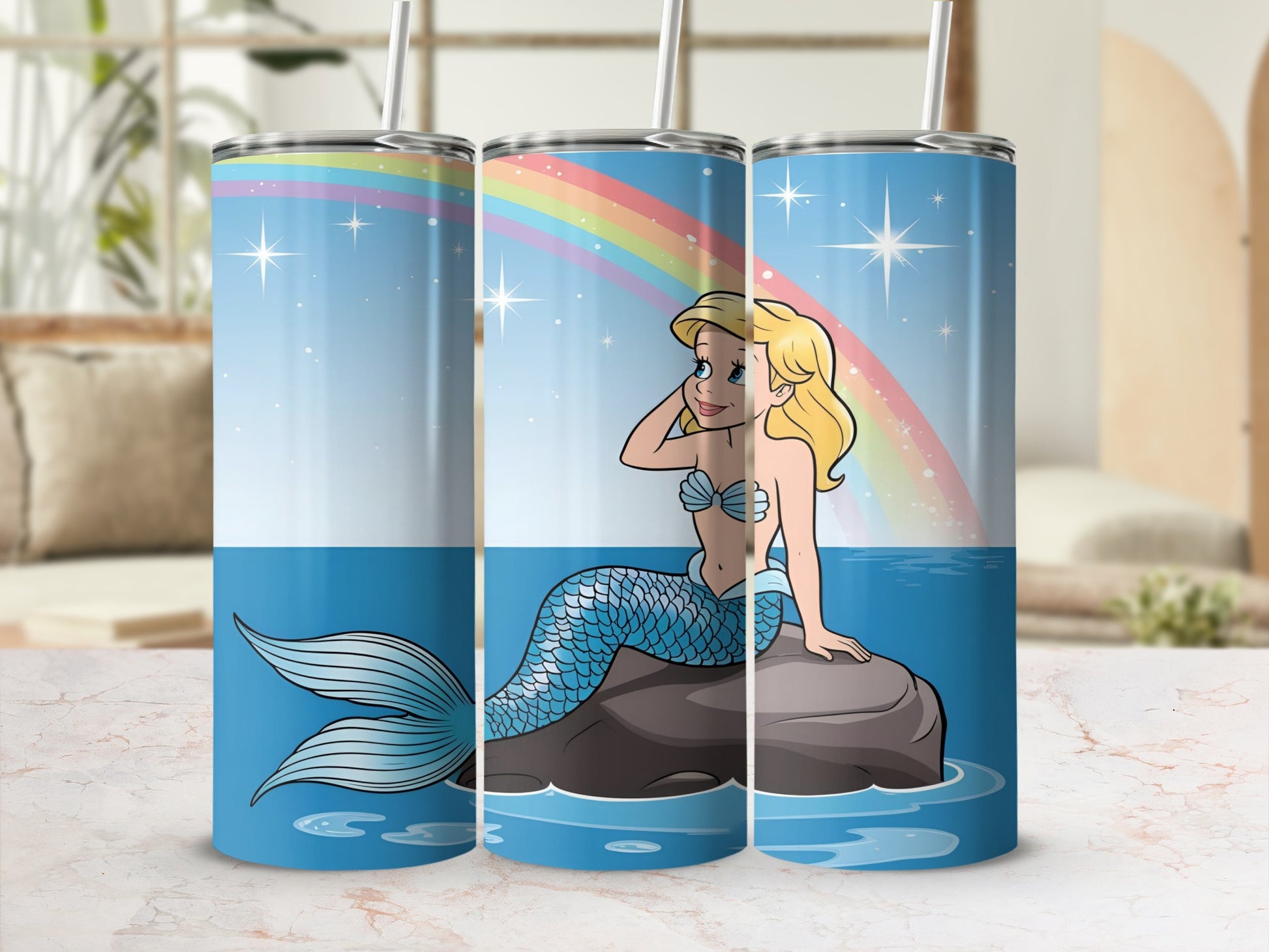 Cartoon mermaid with blue tail sitting on rock, rainbow in background.