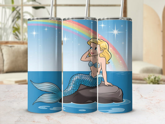 Cartoon mermaid with blue tail sitting on rock, rainbow in background.