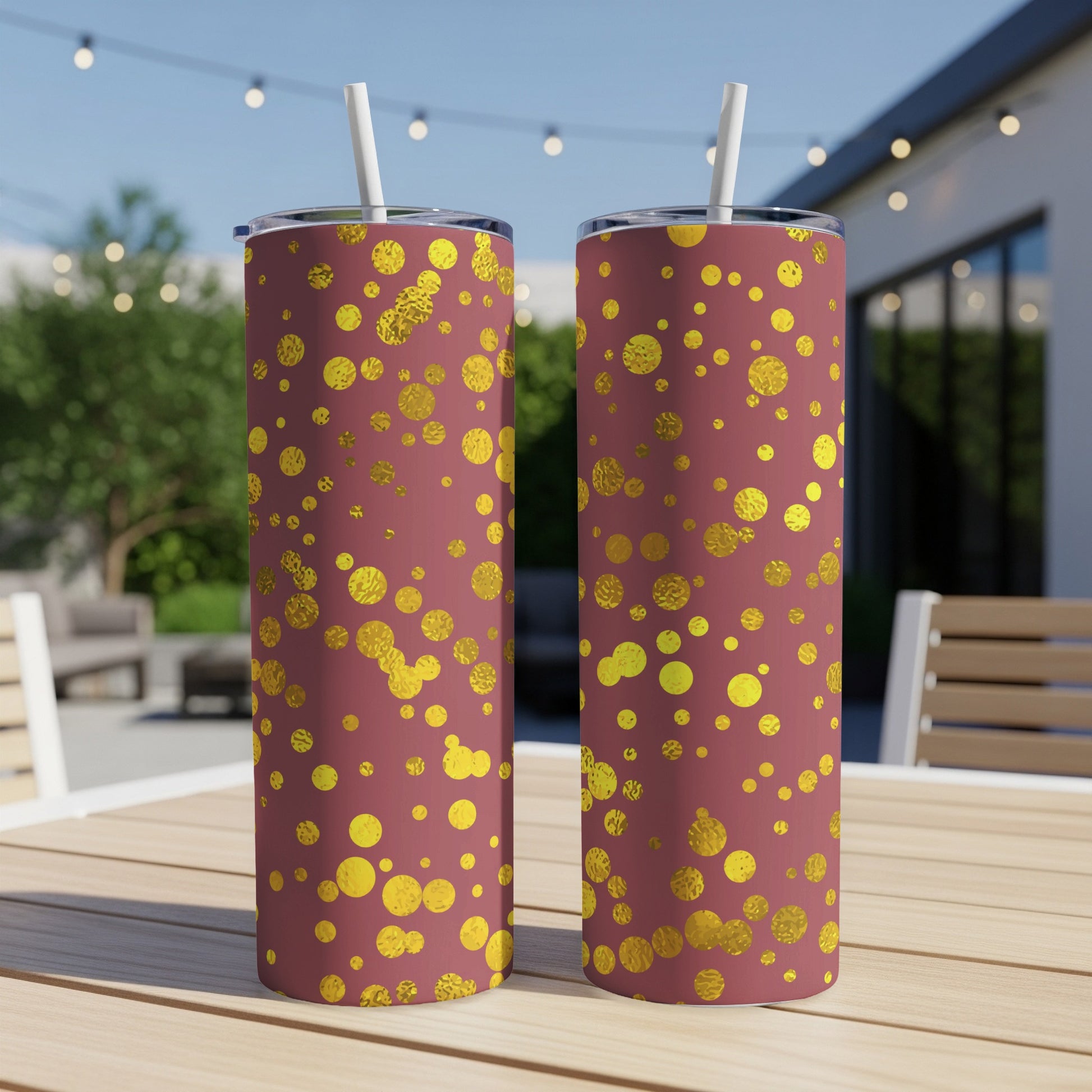 Two maroon tumblers with gold glittery dots, each with a straw.