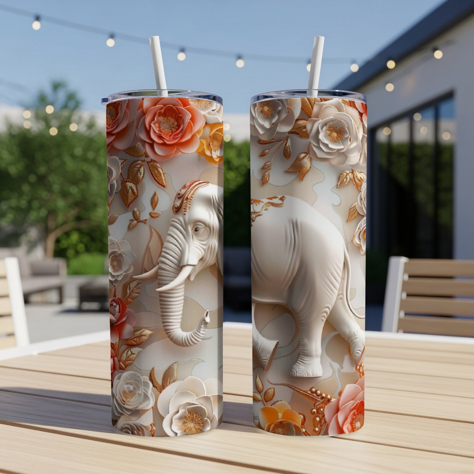 Two tall tumblers with embossed elephant and floral designs on a wooden table.