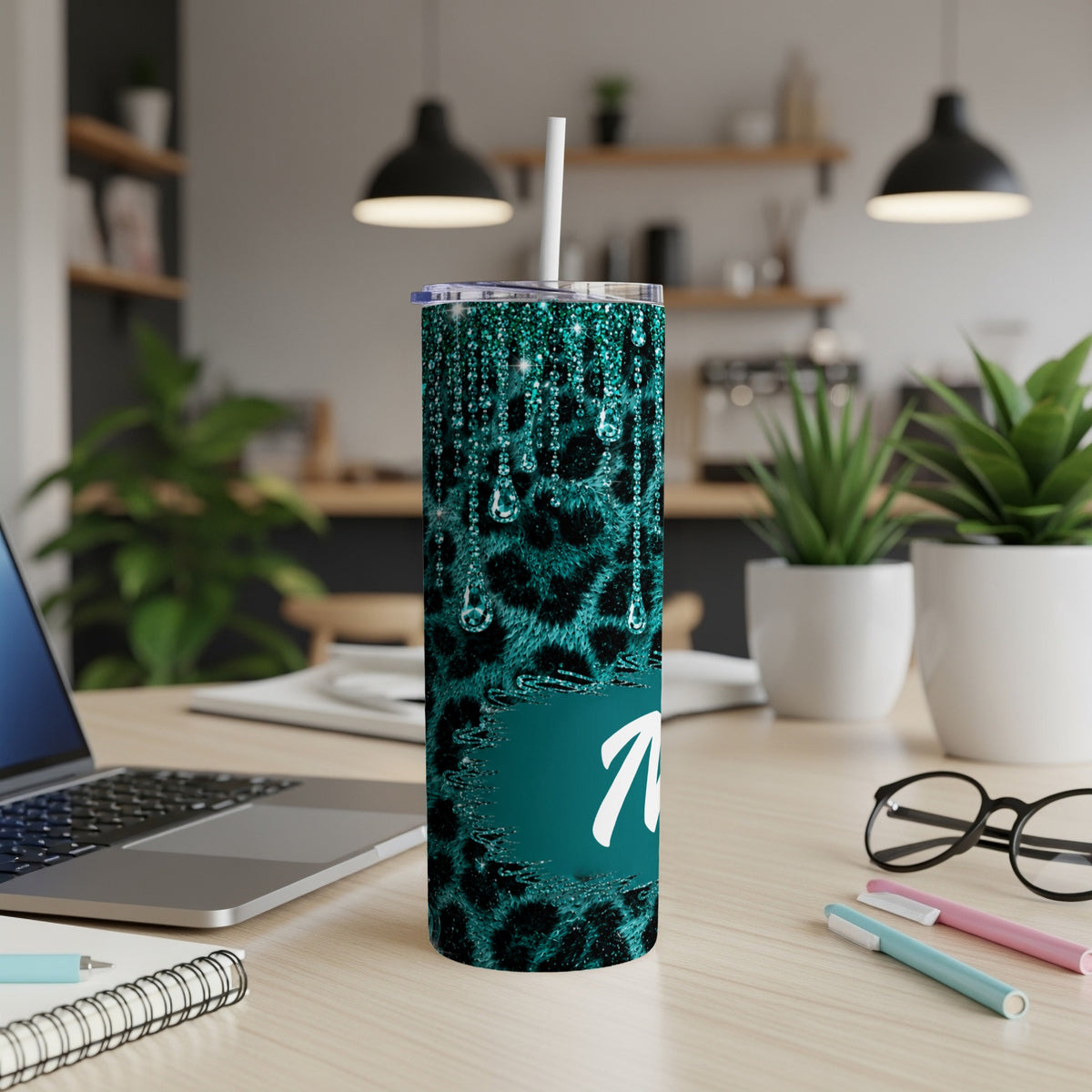 Teal leopard print tumbler with dripping glitter and the letter "M".