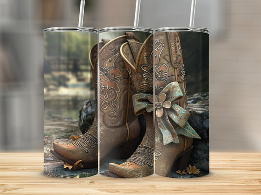 Brown cowgirl boots with floral embellishments and a teal ribbon bow.
