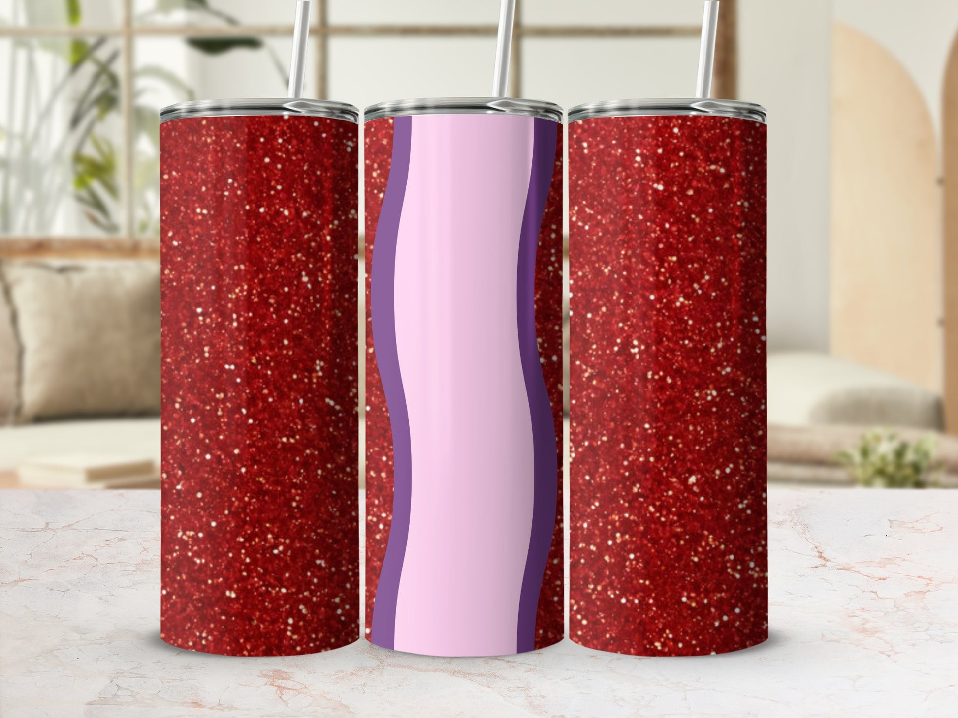 Glittery red and purple tumbler with straw on a marble countertop.