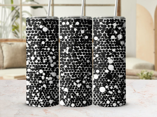 Three tumblers with a black and white bubbly pattern stand on a marble surface.