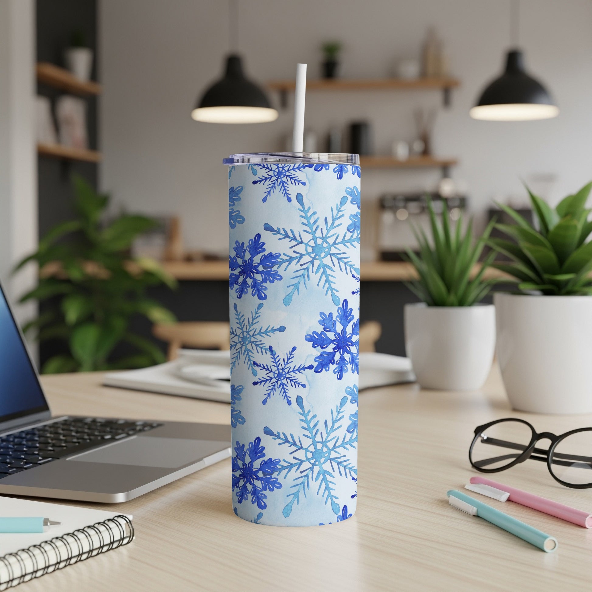 Blue snowflake pattern on a white tumbler with a straw.