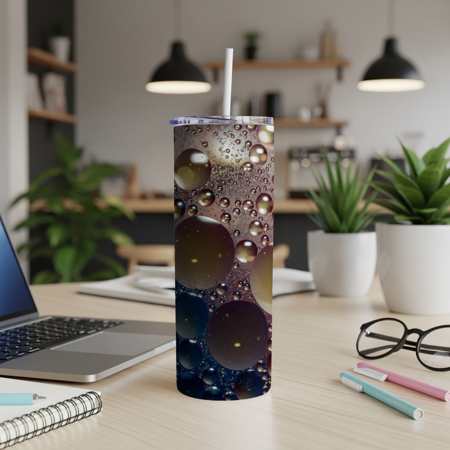 Tumbler with colorful oil and water bubbles design on a desk.