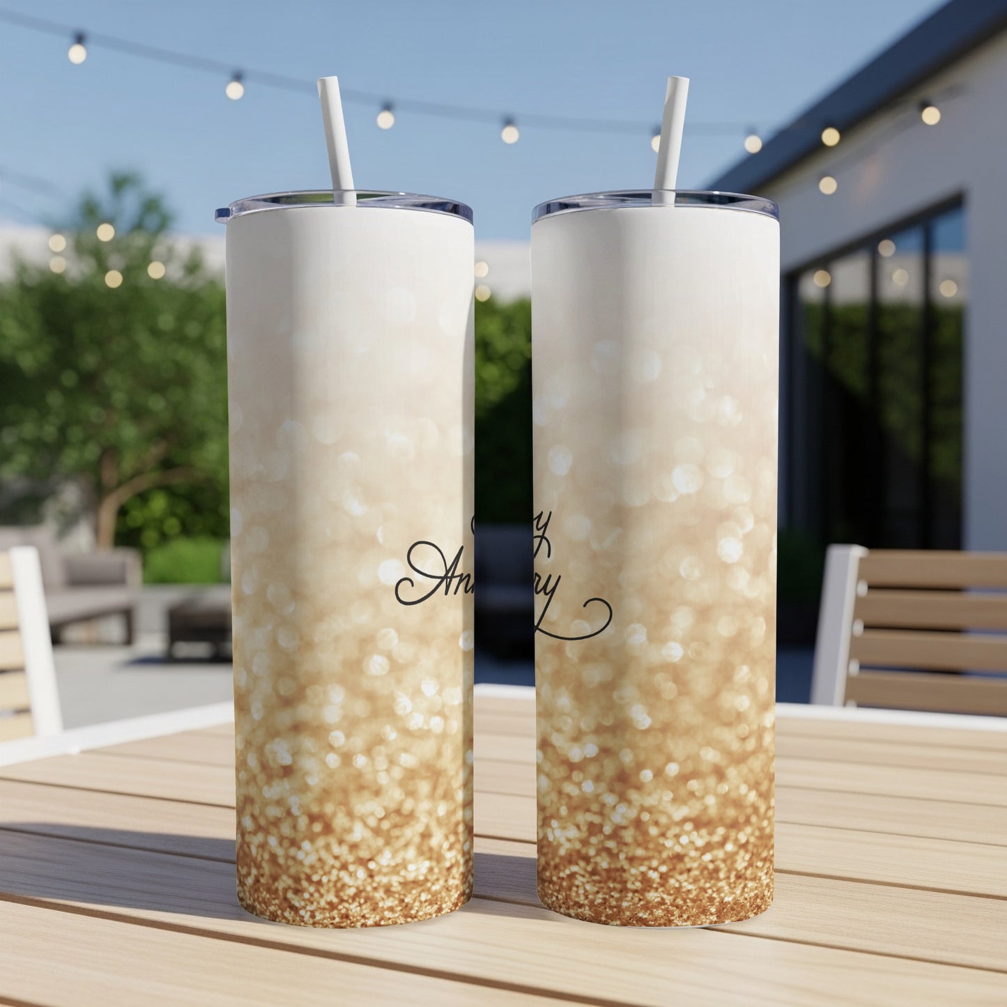 Two glittery tumblers with "Happy Anniversary" text on a table.