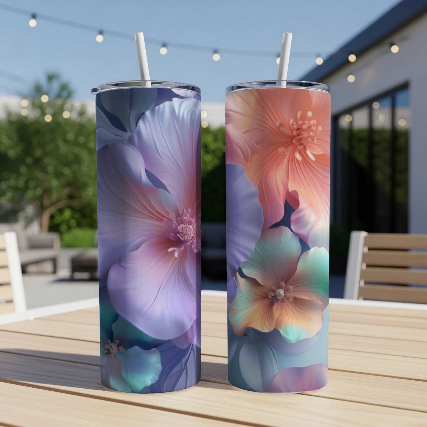 Two tall floral tumblers with straws sit on a table.