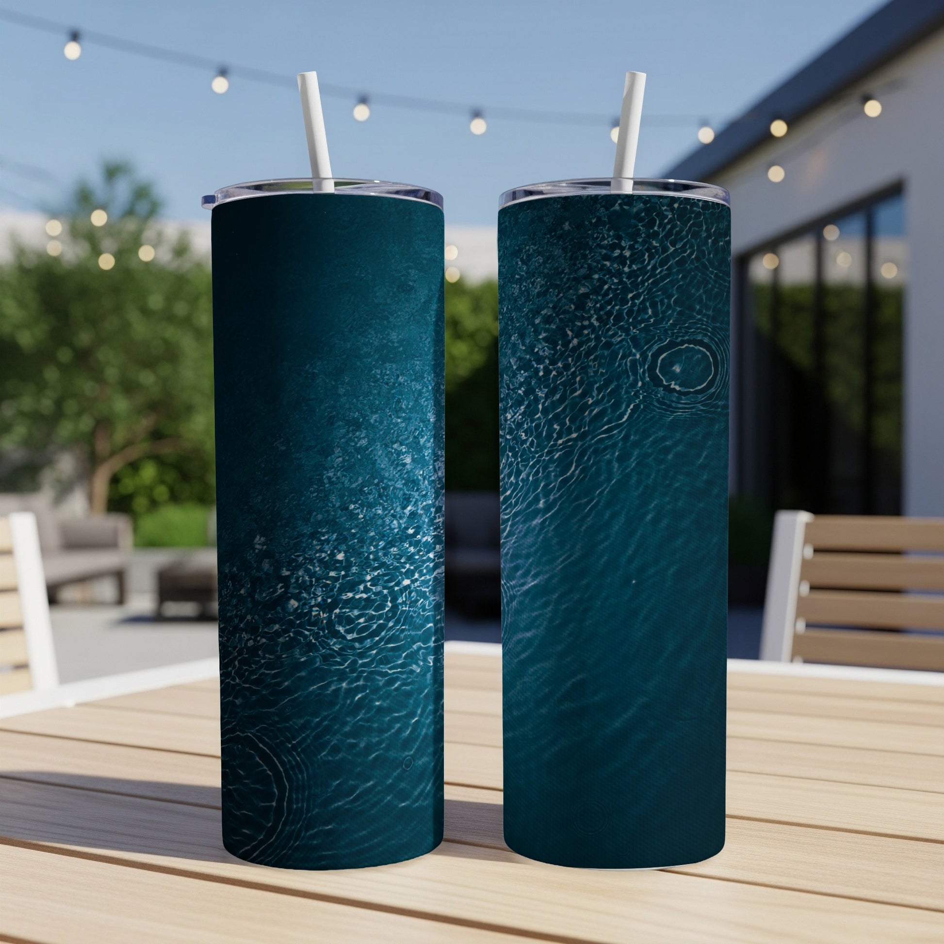Two tumblers with ripple water pattern on outdoor table.
