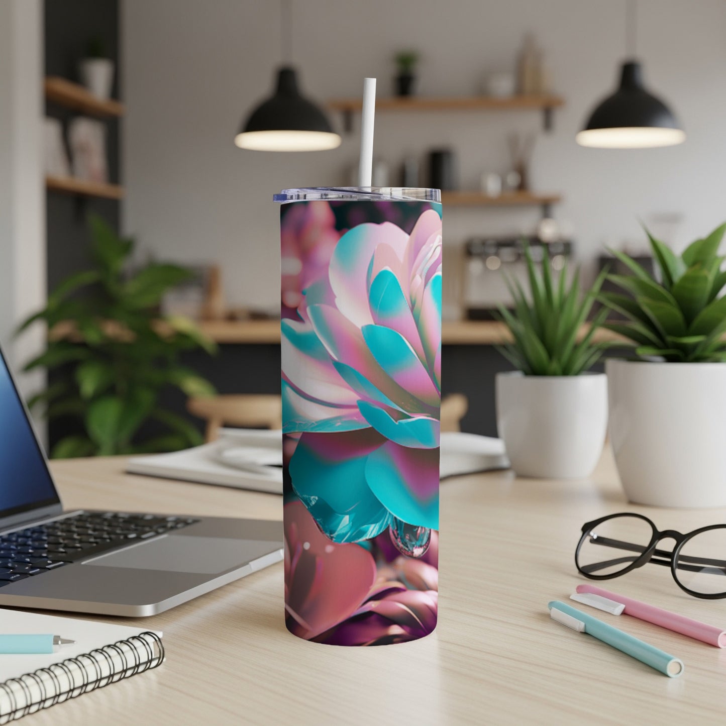 Floral patterned tumbler with straw on a desk.