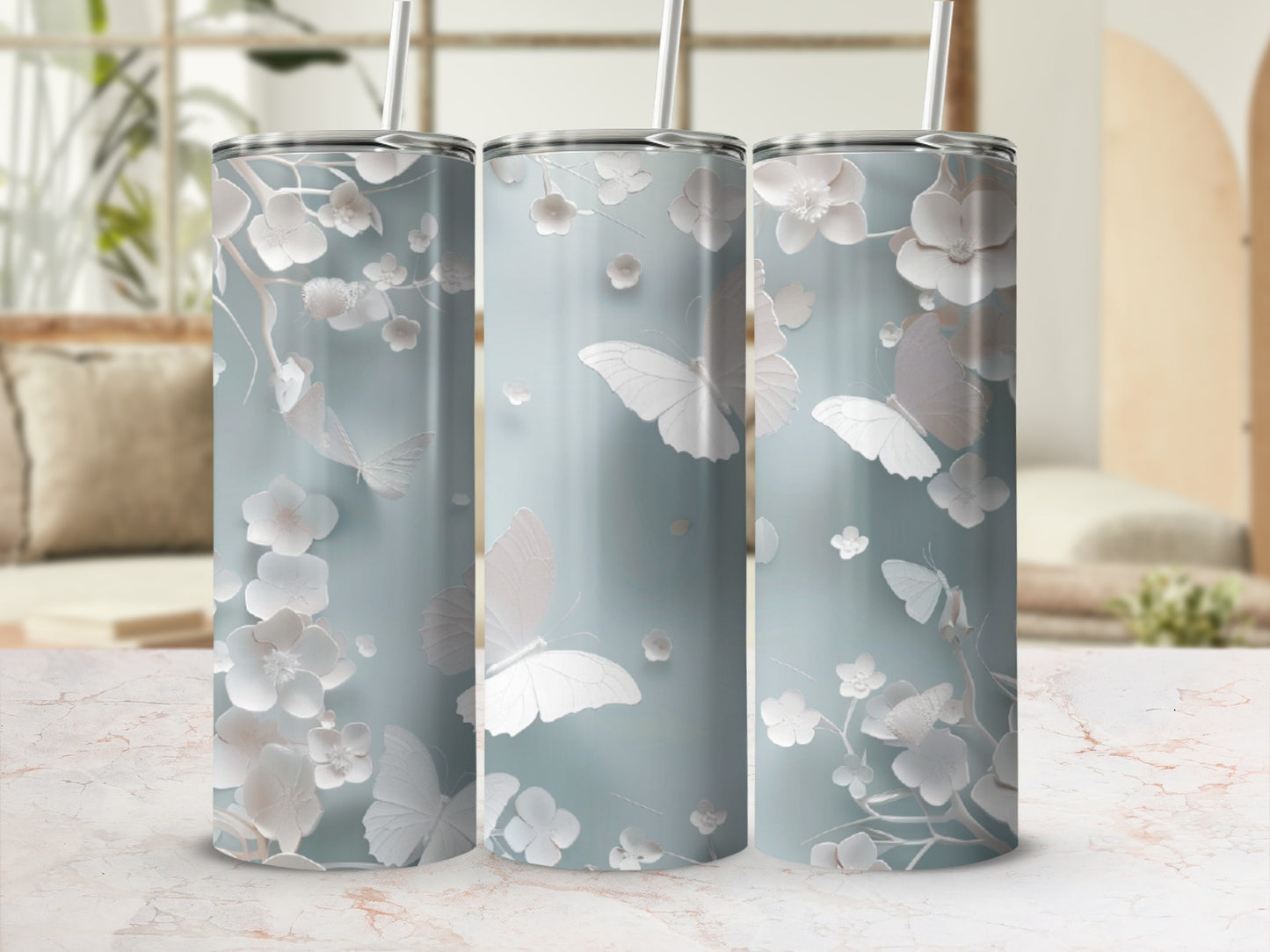 Three tall, slender tumblers with a pale blue background and white floral and butterfly design.