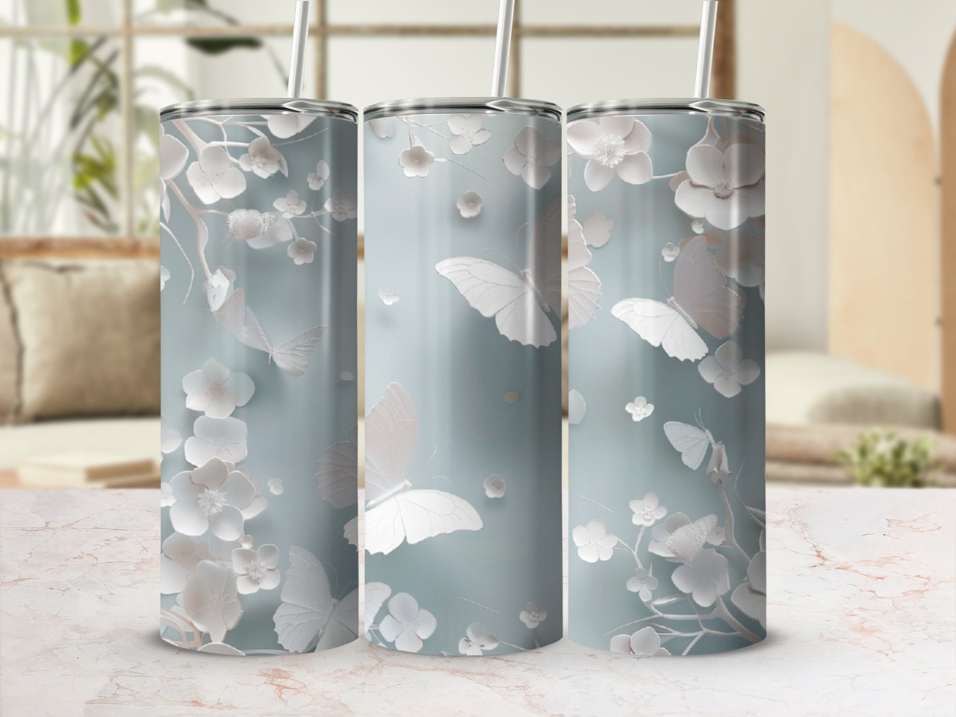 Three tall, slender tumblers with a pale blue background and white floral and butterfly design.