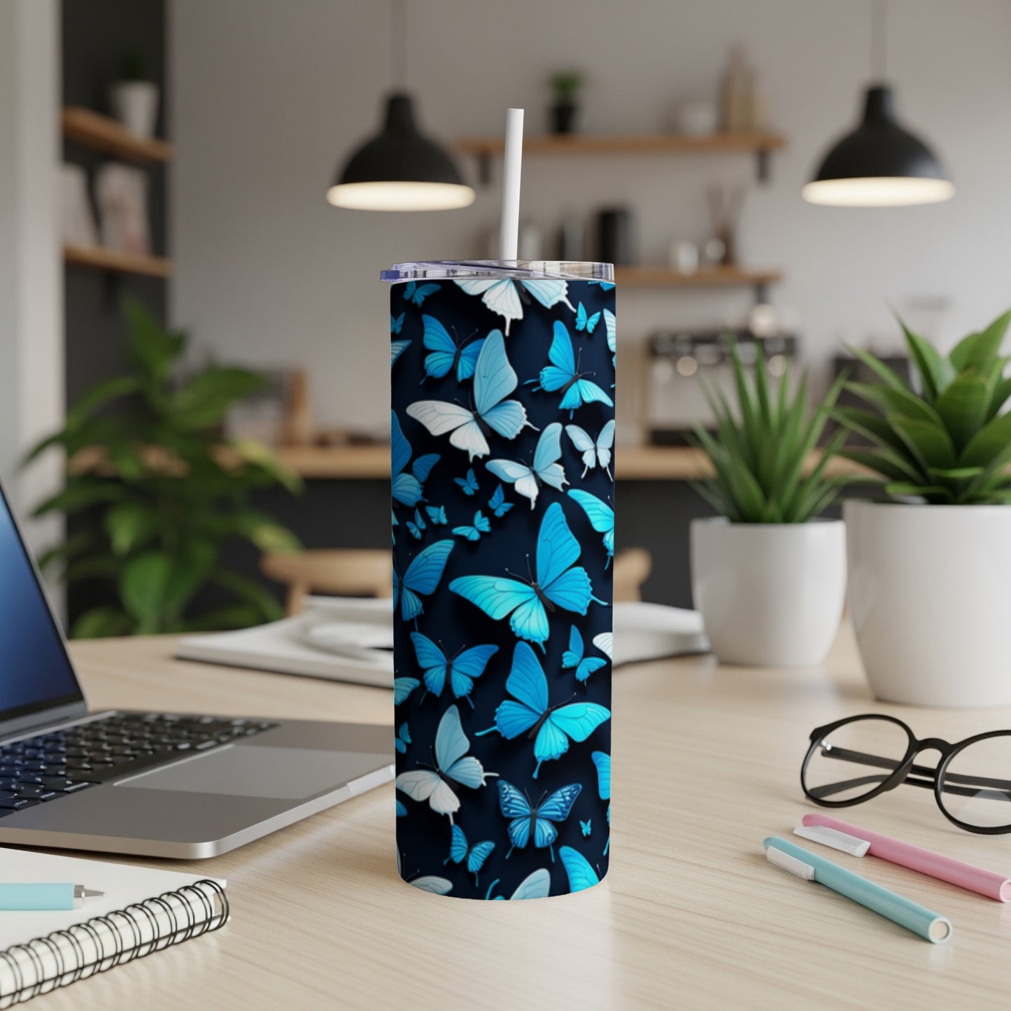 Blue butterflies cover a white skinny tumbler with a straw.