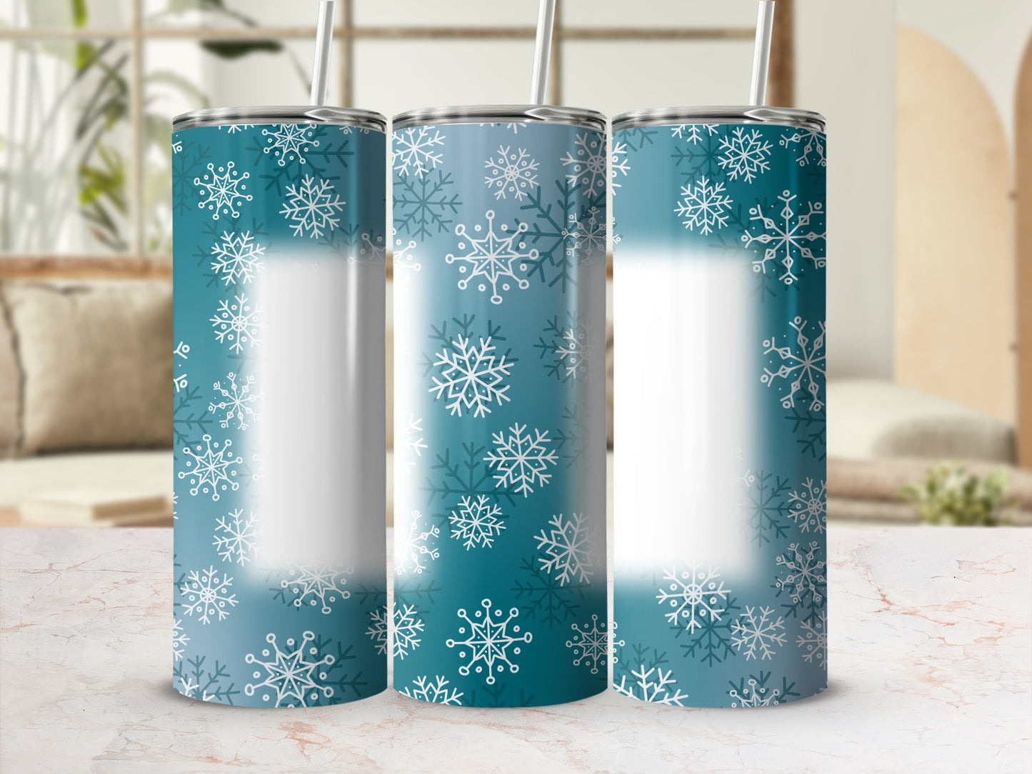 Three teal tumblers with white snowflake pattern and straws.