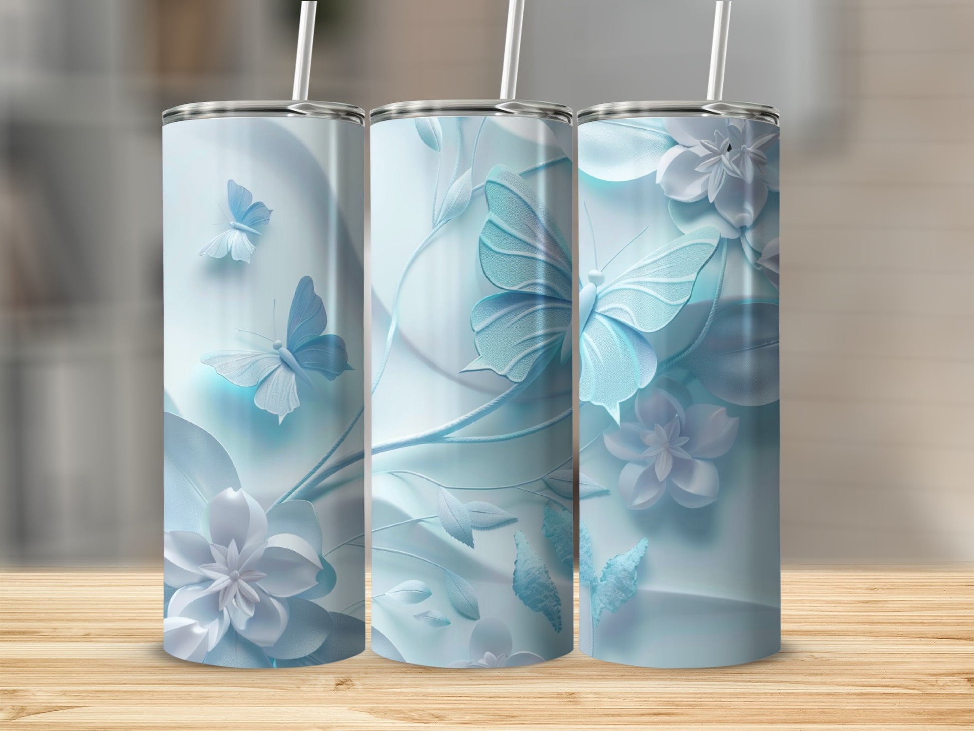 Three pale blue tumblers with raised floral and butterfly designs.