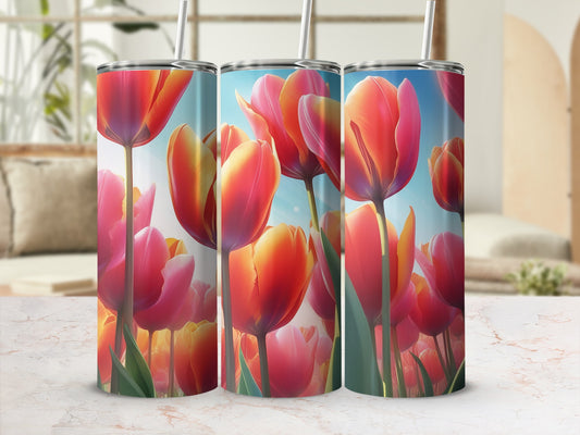 Three tumblers with a vibrant floral tulip design against a blurred background.