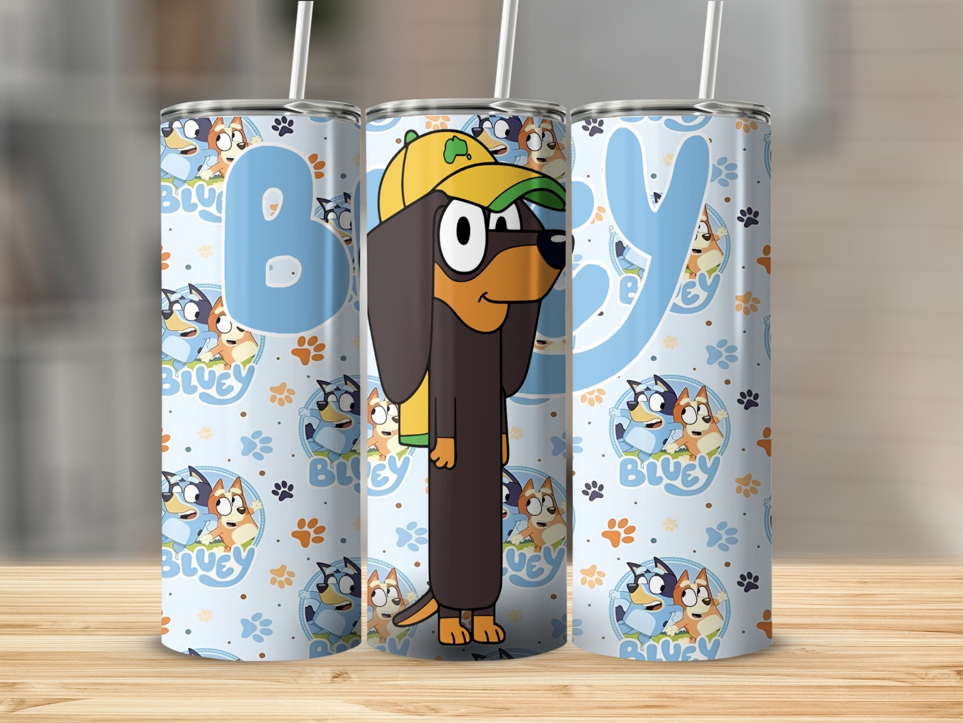 Bluey character tumbler with yellow cap and green bandana, light blue background.