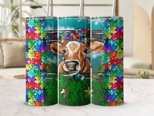 Tumbler with colorful puzzle border and cow wearing bandana.
