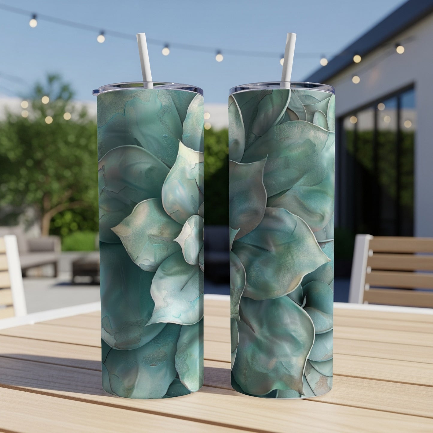 Two tall tumblers with a teal succulent floral design, on a wooden table.