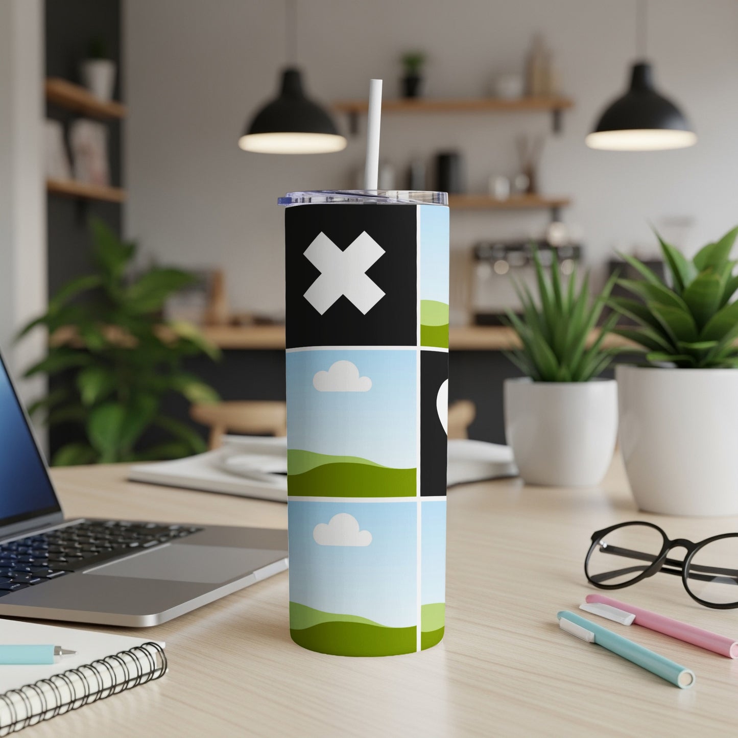 Tumbler with abstract design featuring a large white X, clouds, and green hills.