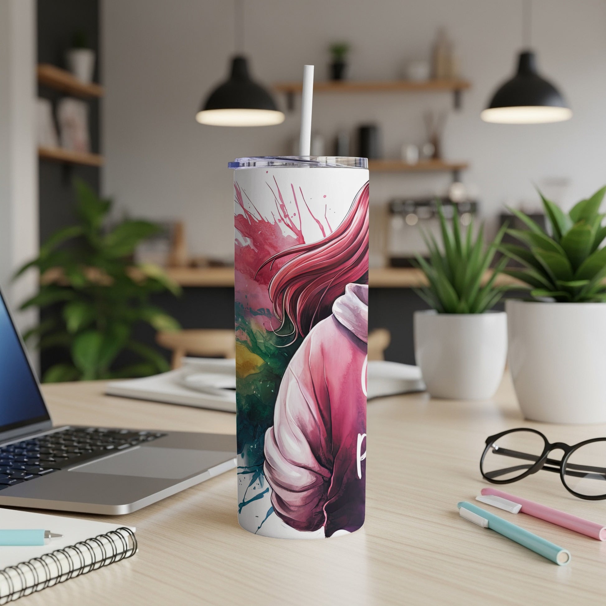 Pink and green abstract art on a white tumbler with a straw.