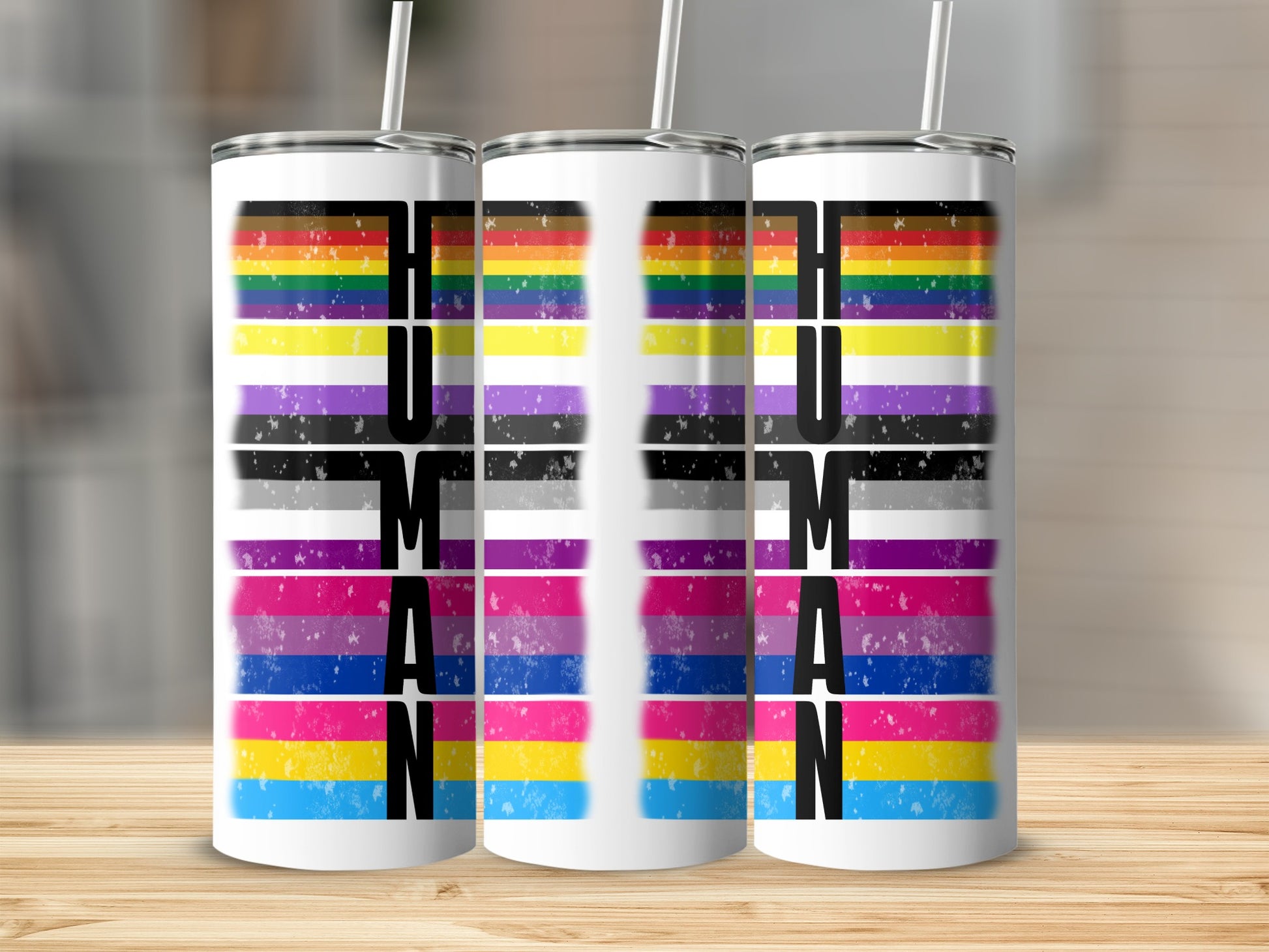 Three tumblers with "HUMAN" text and rainbow-colored stripes.