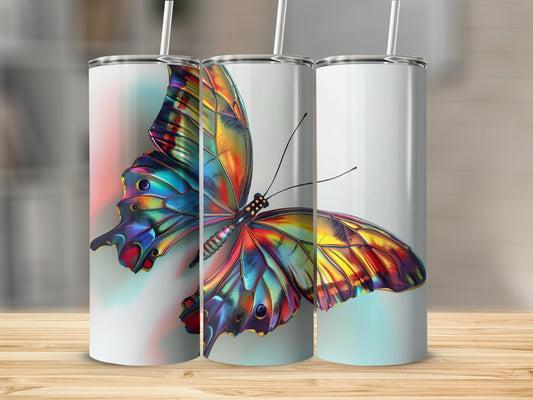 Three tumblers with iridescent butterfly designs on a wooden surface.