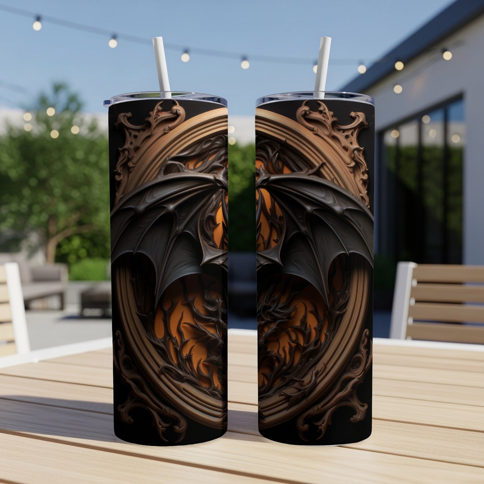 Two tumblers with a black dragon wing design and ornate frame on a table outdoors.