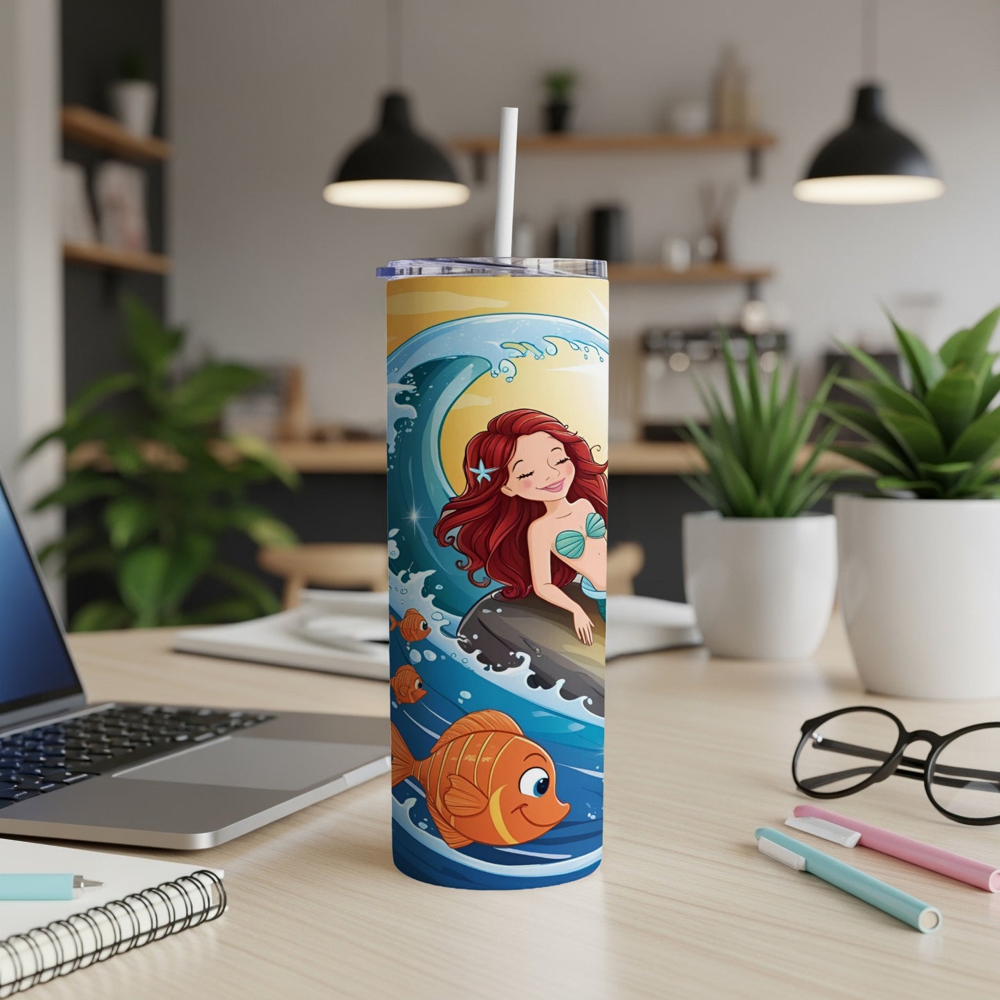 Mermaid and fish illustration on a blue and yellow striped tumbler with a straw.