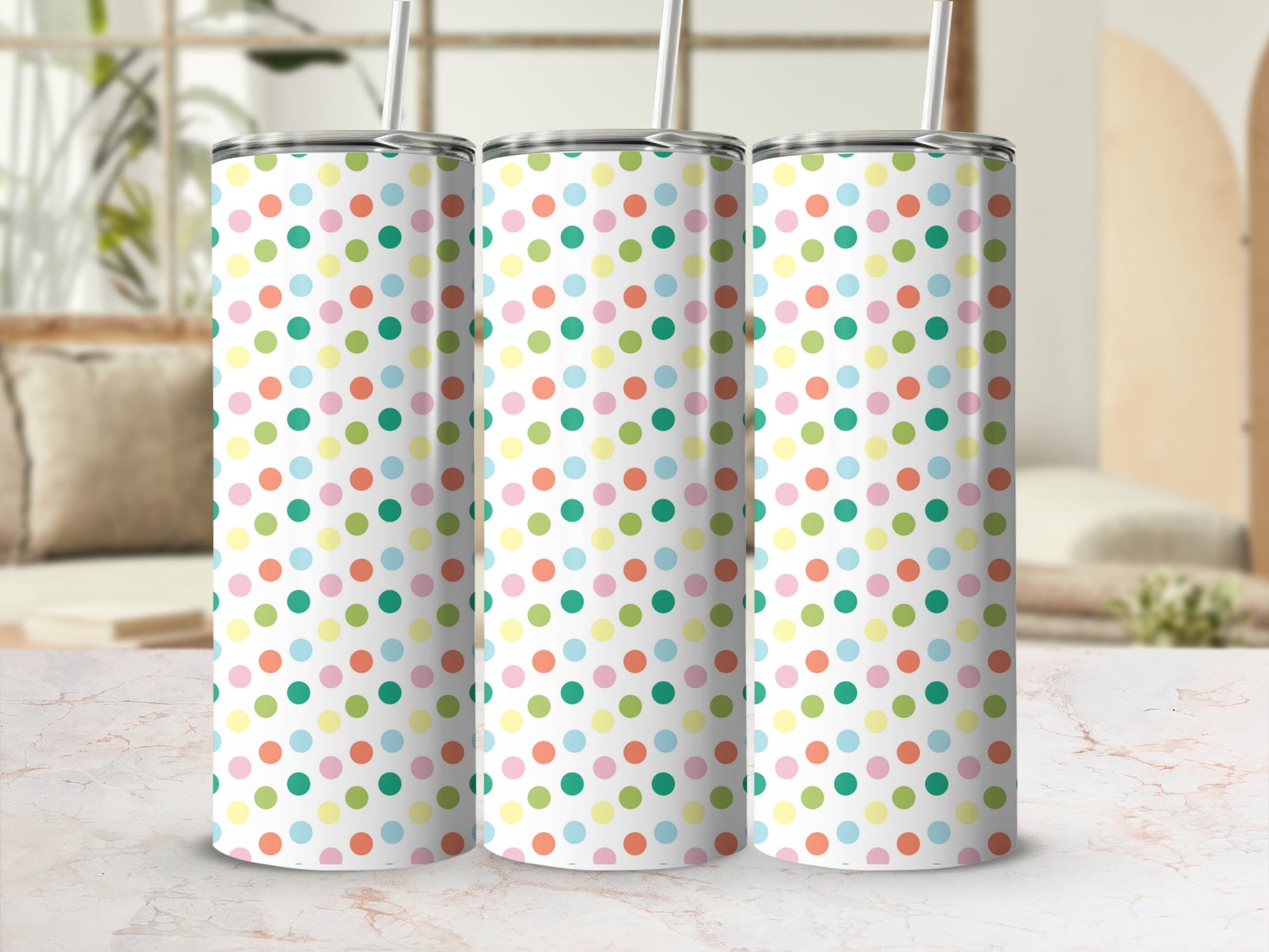 Three polka dot tumblers with colorful dots on a table.