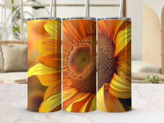Sunflower tumblers with straws against a blurred background.